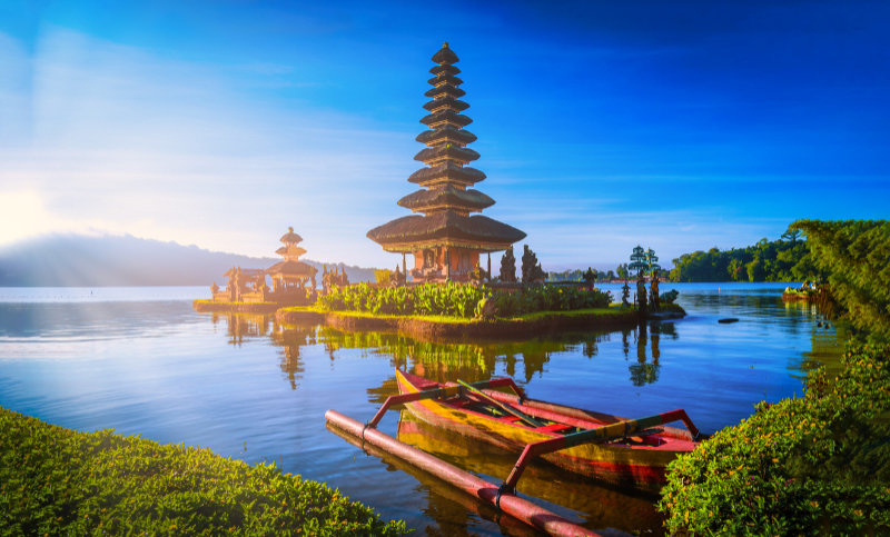 Pura Ulun Danu Bratan, Hindu temple with boat on Bratan lake landscape at sunrise in Bali, Indonesia.