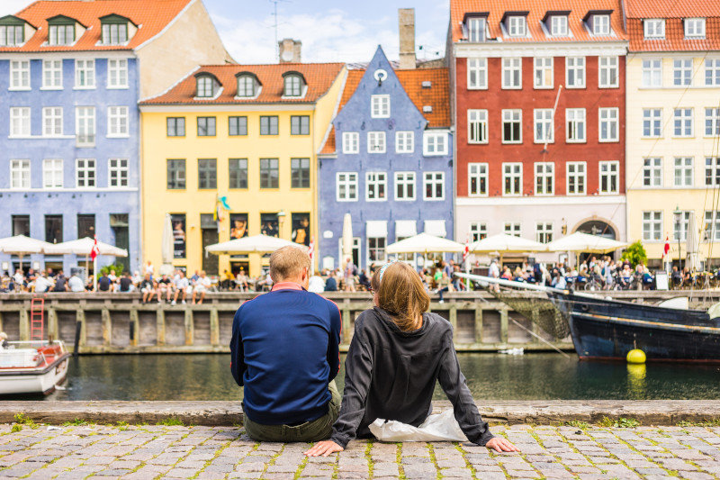 Tourists enjoying the scenic summer view of Nyhavn pier. Colorfu